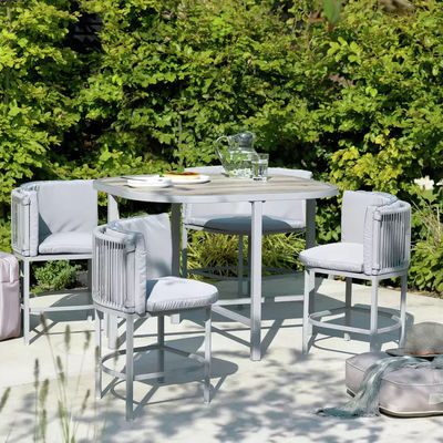 Massimizza il tuo spazio esterno con questo set da pranzo in tessuto di rattan e acciaio che risparmia spazio